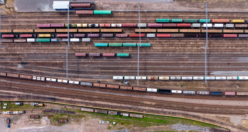 Top-down view of a railway yard with multiple tracks and colorful freight trains, demonstrating the Pegasus TRK Evo’s ability to capture high-accuracy data for rail infrastructure projects, maintenance, and safety inspections.